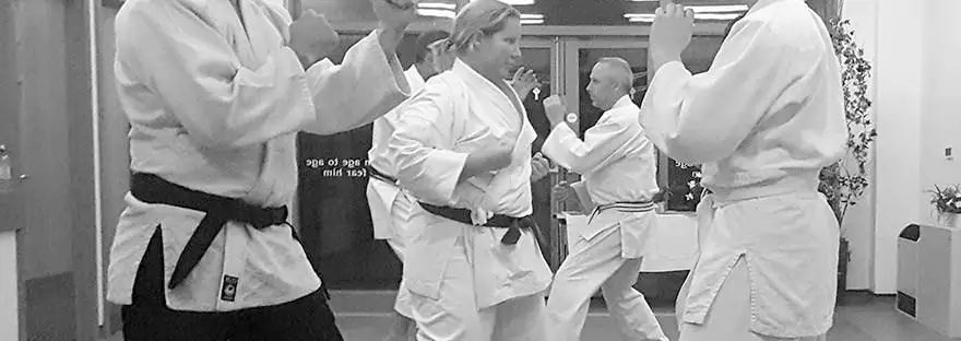This image shows several adult Satorikan Jujutsu students in various stances within the Saltash dojo